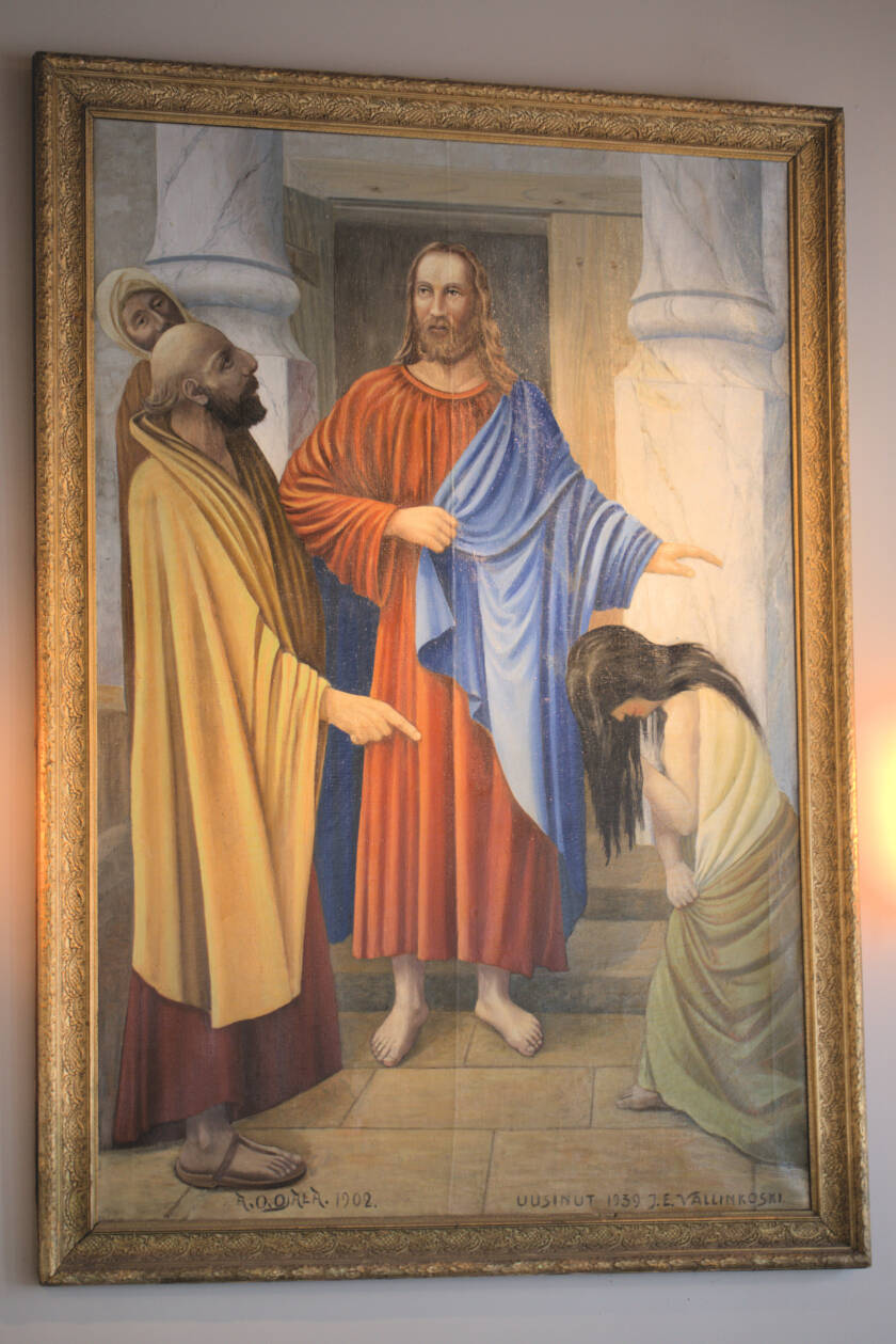 Alttaritaulu, jossa Jeesus siunaa polvistuneen naisen. Vieressä mies, joka osoittaa naista sormella tuomitsevan näköisenä.