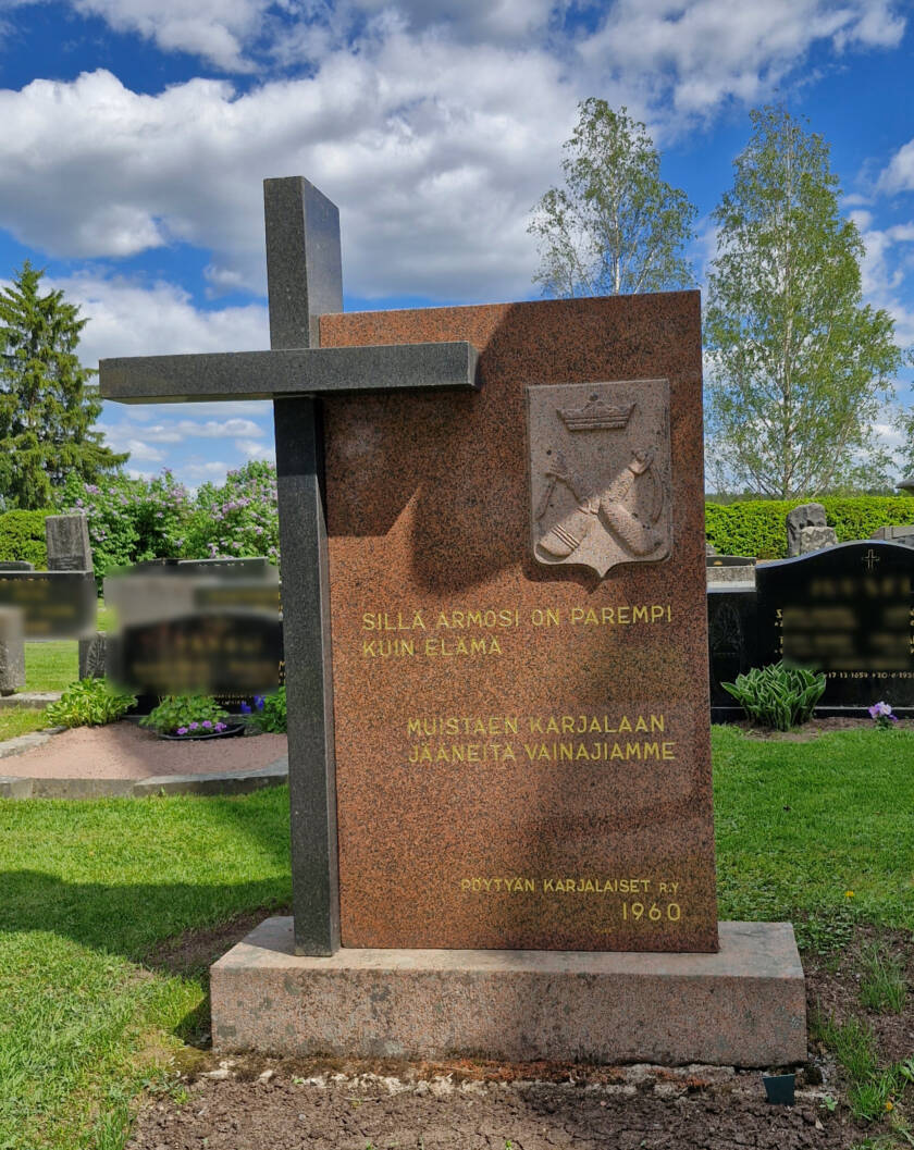 Kivipaasi, jonka sivussa korkeampi rautaristi.