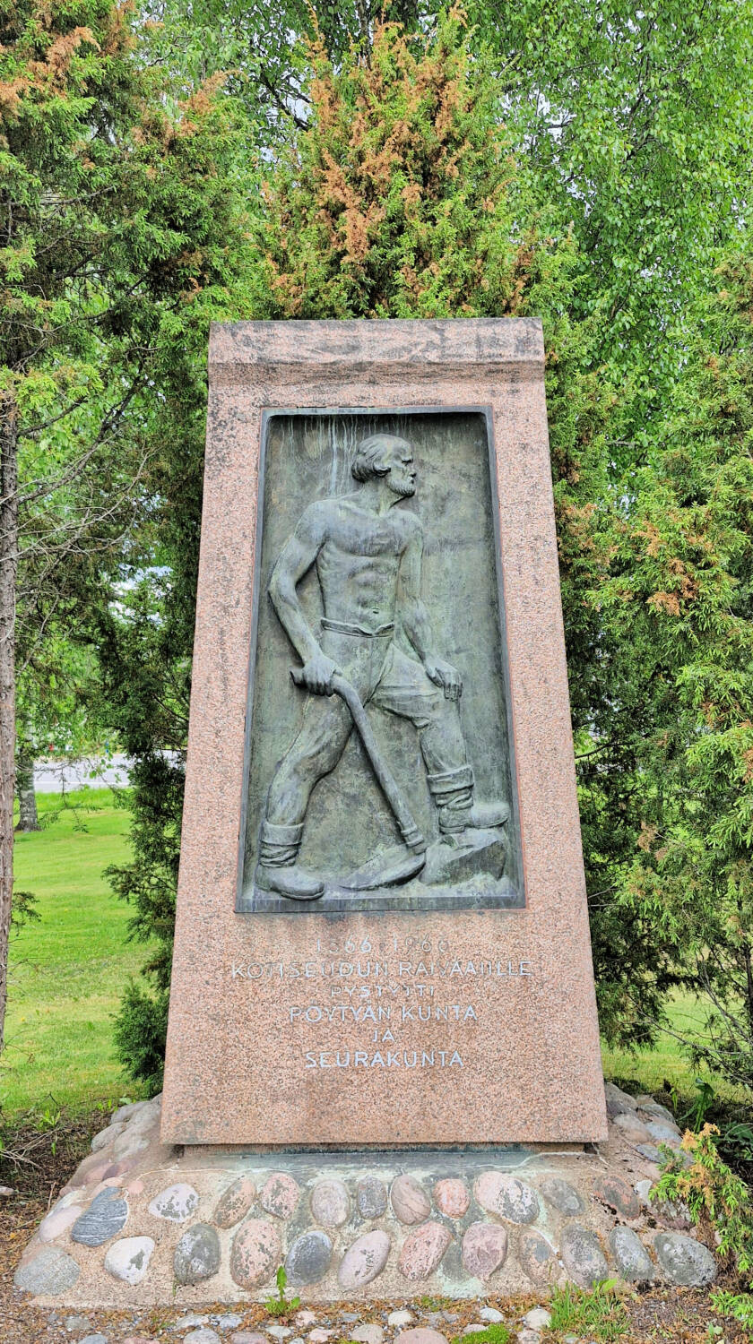 Kivipaasi, jossa upotettuna ihmishahmo, jolla kädessään kuokka.