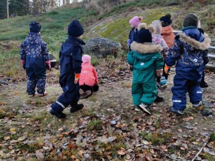 Lapsia ulkoilemassa, syksyisellä pihalla.