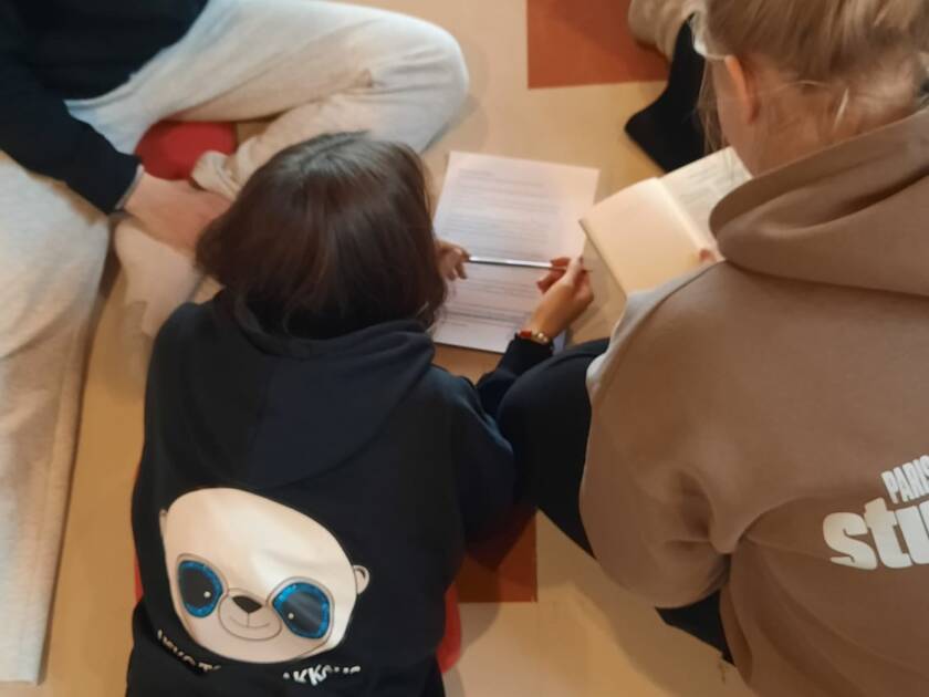 Nuoria lukemassa lattialla piirissä