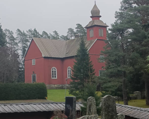 Puukirkko sumuisella vanhalla hautausmaalla.
