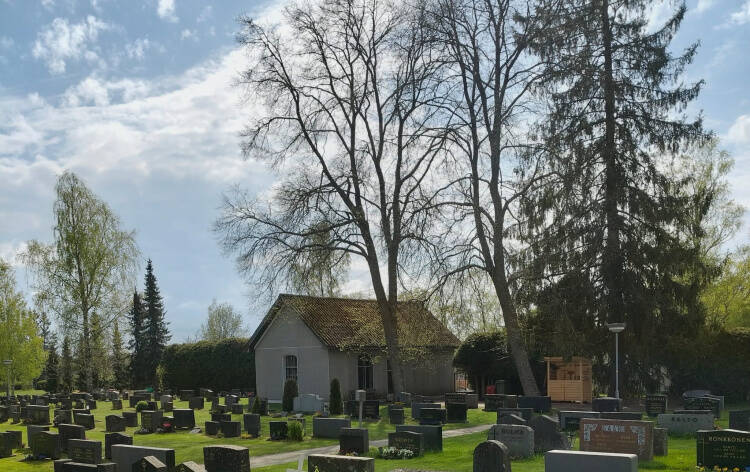 Pieni rakennus hautausmaan laidalla.