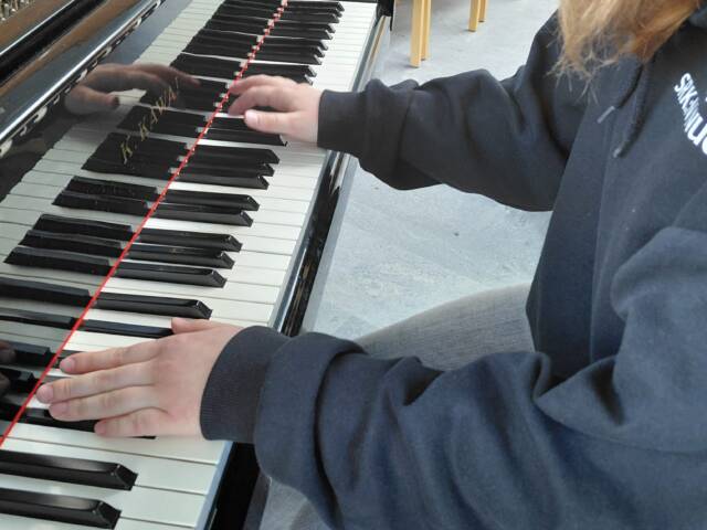 Nuori soittamassa pianoa.