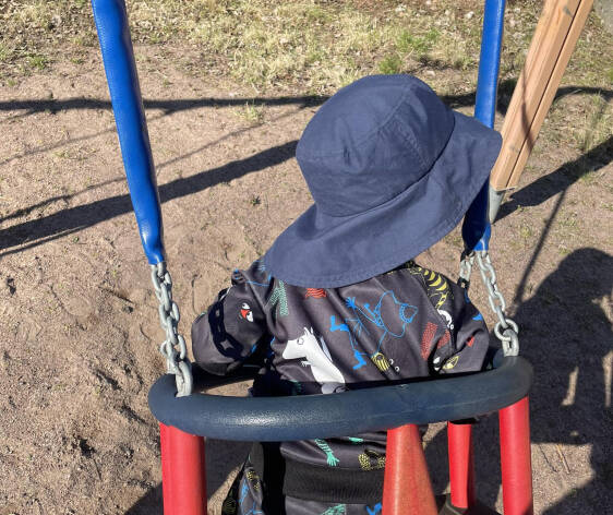 pieni lapsi istuu keinussa